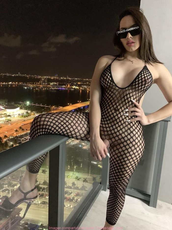 Preciosa hembra transexual en sexy body en el balcón