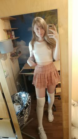 Adorable mariquita rubia adolescente se toma una selfie vestida de colegiala